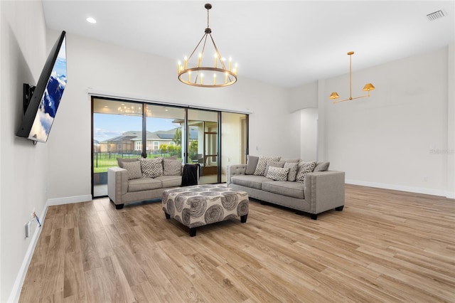 living area with light wood-style flooring, visible vents, a chandelier, and baseboards