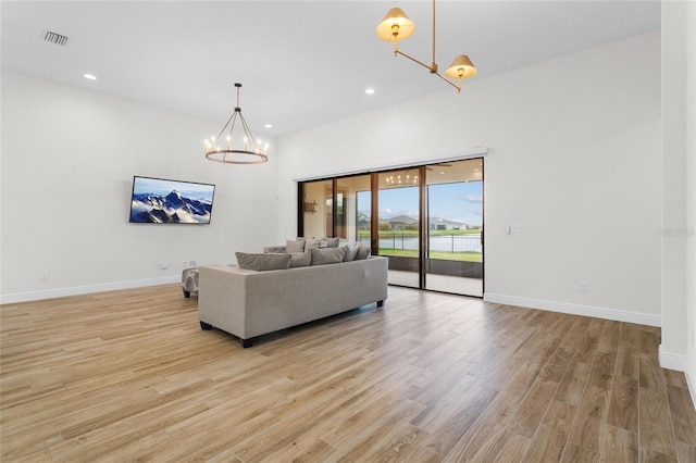 living room featuring light wood-style floors, recessed lighting, baseboards, and an inviting chandelier