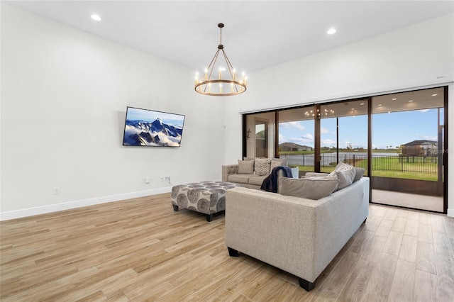 living area featuring light wood-style floors, baseboards, a chandelier, and recessed lighting