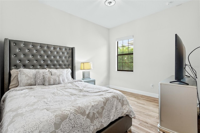 bedroom featuring baseboards and wood finished floors