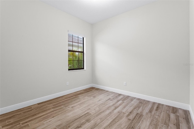 spare room featuring light wood-style flooring and baseboards