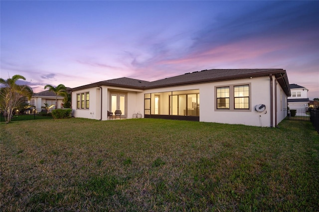 back of house featuring stucco siding, a fenced backyard, and a yard