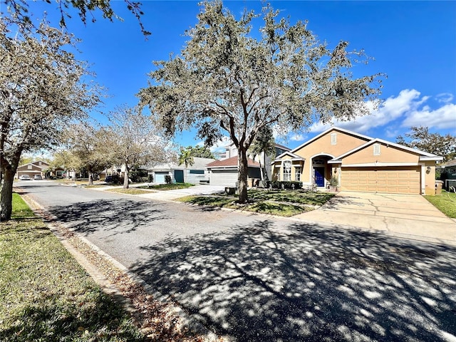 view of front of house with driveway, an attached garage, and stucco siding