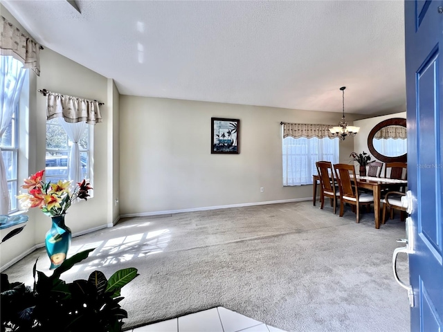 dining area featuring carpet, baseboards, and a chandelier