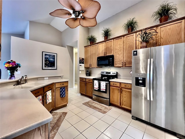 kitchen with stainless steel appliances, light tile patterned flooring, a sink, and light countertops