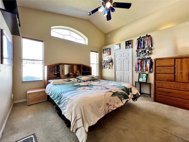 bedroom with baseboards, lofted ceiling, ceiling fan, carpet flooring, and a closet