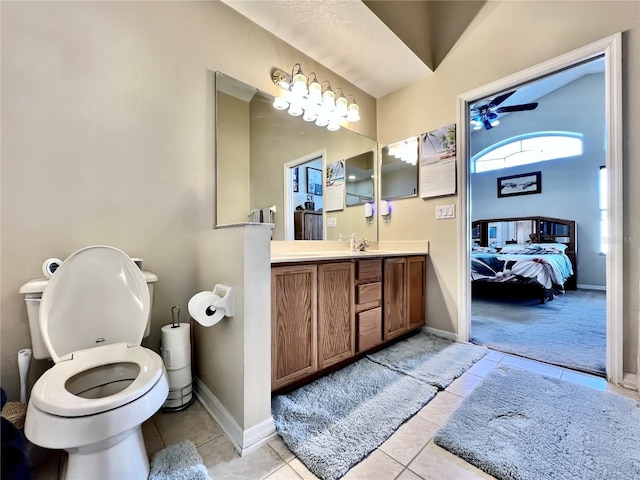 ensuite bathroom with toilet, ensuite bathroom, vanity, tile patterned flooring, and baseboards