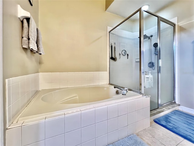 bathroom with a stall shower, tile patterned flooring, and a garden tub