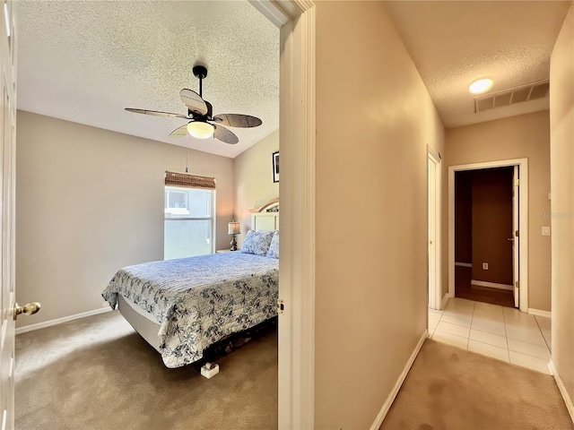 tiled bedroom with baseboards, visible vents, a textured ceiling, and carpet flooring