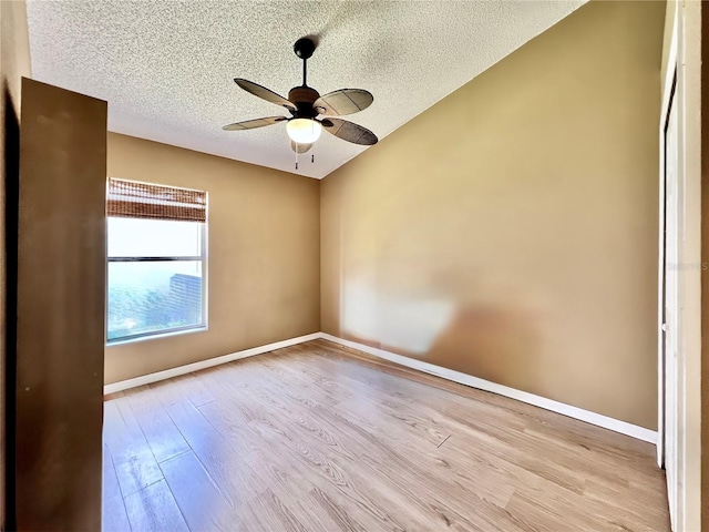 spare room featuring ceiling fan, a textured ceiling, wood finished floors, and baseboards