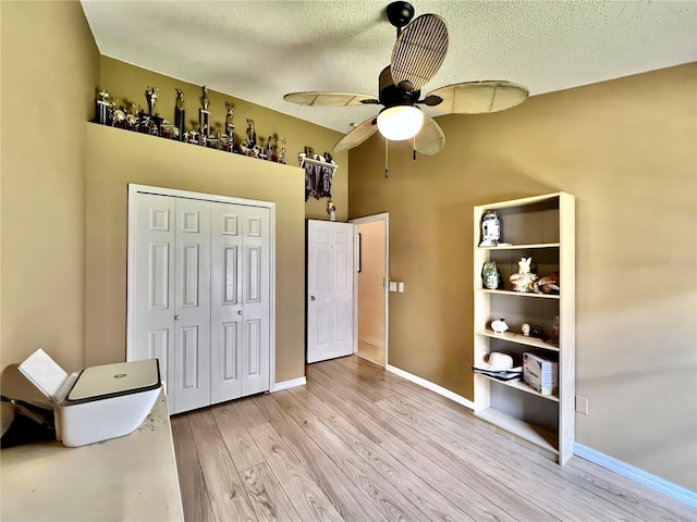 bedroom with a textured ceiling, wood finished floors, and baseboards