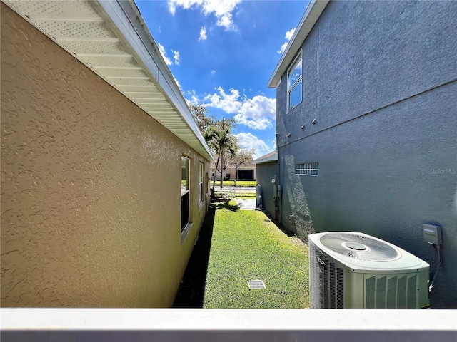 view of side of home featuring cooling unit and stucco siding