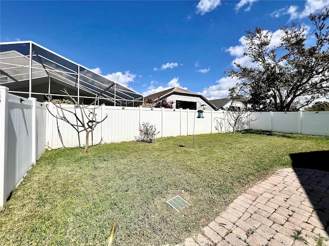 view of yard with a lanai and a fenced backyard