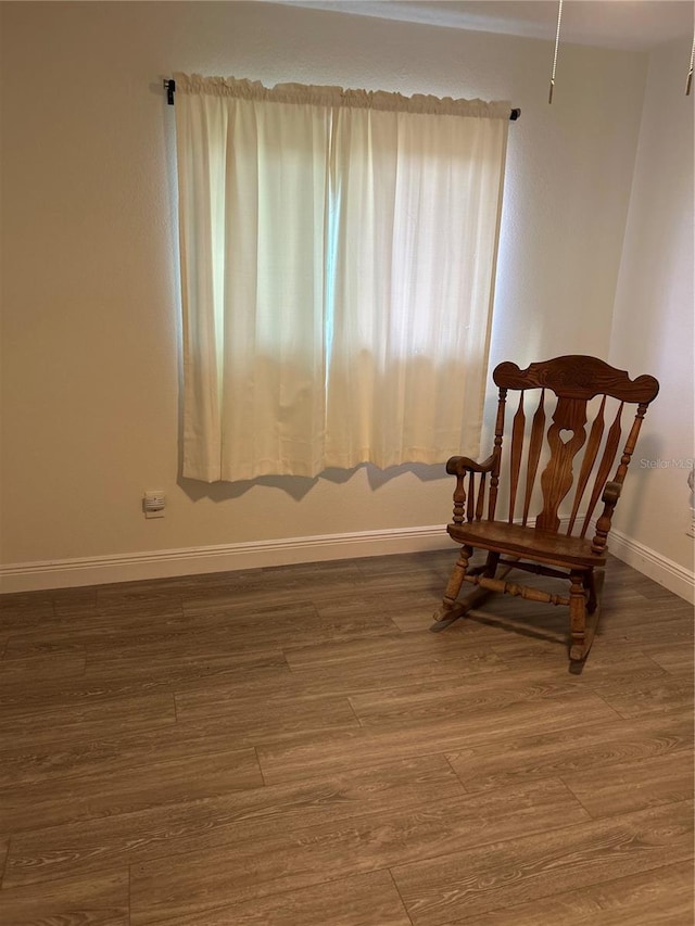 sitting room featuring baseboards and wood finished floors