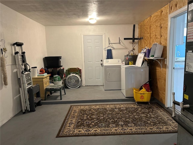 laundry room featuring laundry area, water heater, and separate washer and dryer