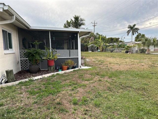 view of yard with a sunroom and fence