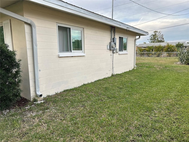 view of side of home featuring a yard and fence