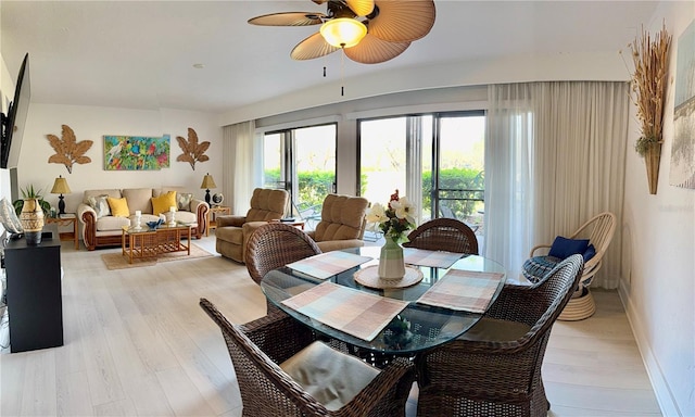 dining area with baseboards, light wood-type flooring, and a ceiling fan