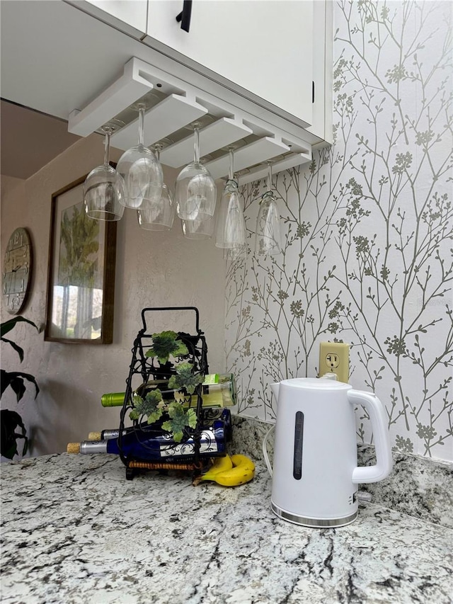 details featuring light stone counters and white cabinetry