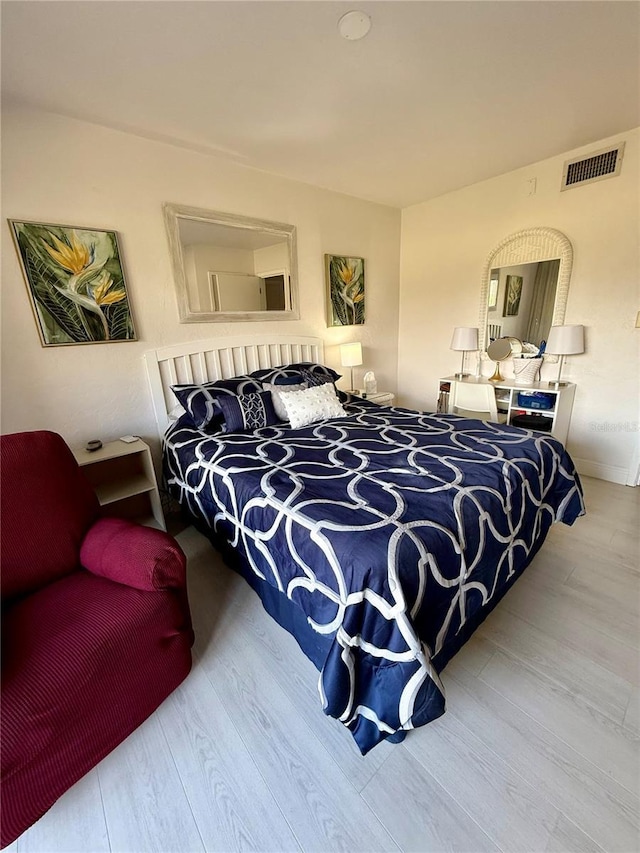 bedroom featuring visible vents and wood finished floors