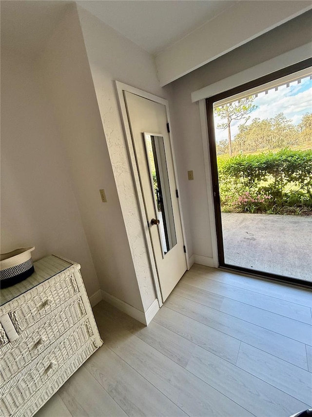 doorway to outside with light wood-type flooring and baseboards