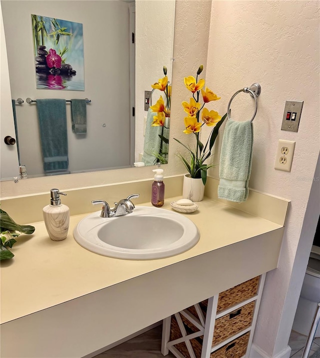 bathroom featuring vanity and a textured wall