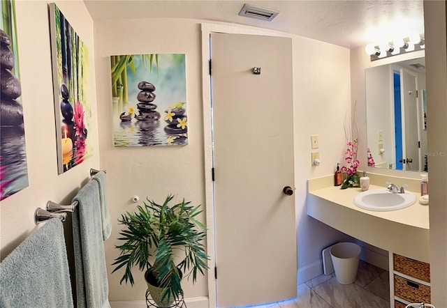 bathroom with visible vents and a sink