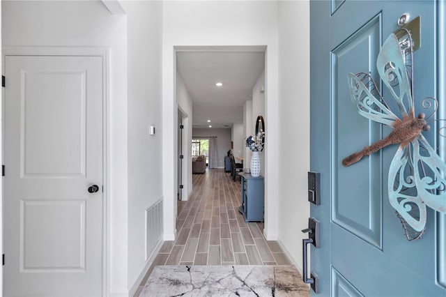 foyer with wood tiled floor, visible vents, baseboards, and recessed lighting