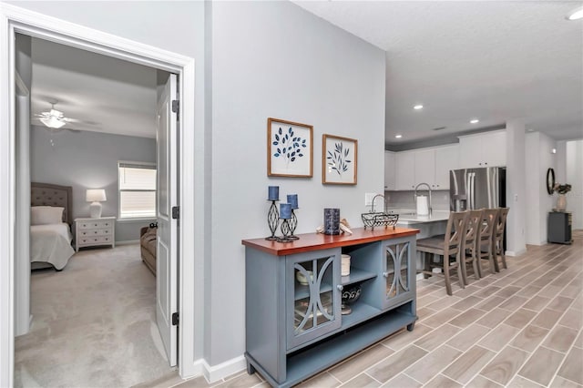 hall featuring recessed lighting and baseboards