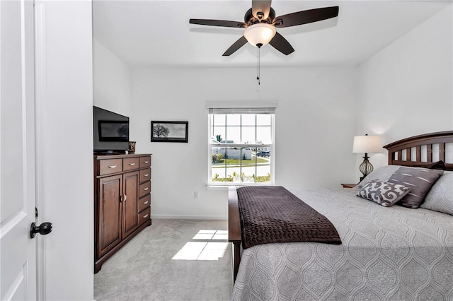 bedroom with a ceiling fan, light colored carpet, and baseboards