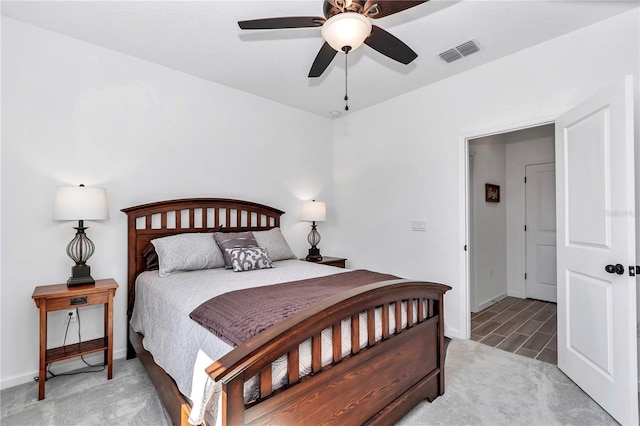 bedroom featuring baseboards, visible vents, a ceiling fan, and light colored carpet