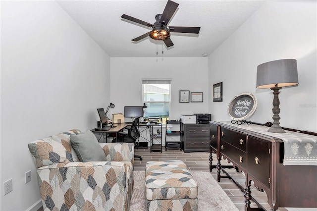 office area with ceiling fan, baseboards, and wood tiled floor