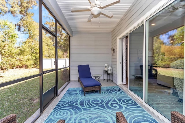 unfurnished sunroom with ceiling fan