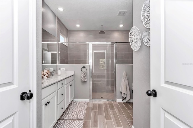 bathroom featuring visible vents, a stall shower, vanity, and recessed lighting