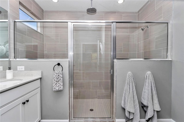 bathroom with a stall shower, recessed lighting, and vanity