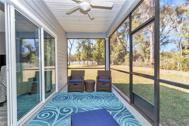 unfurnished sunroom featuring a ceiling fan