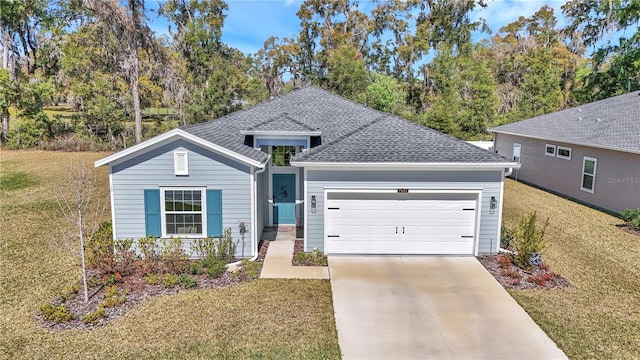 view of front of property with concrete driveway, an attached garage, a front lawn, and a shingled roof