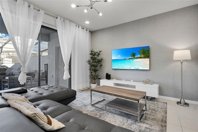 living area with a notable chandelier, baseboards, and tile patterned floors