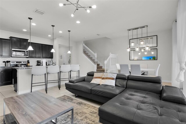 living room with visible vents, stairway, an inviting chandelier, light tile patterned flooring, and recessed lighting