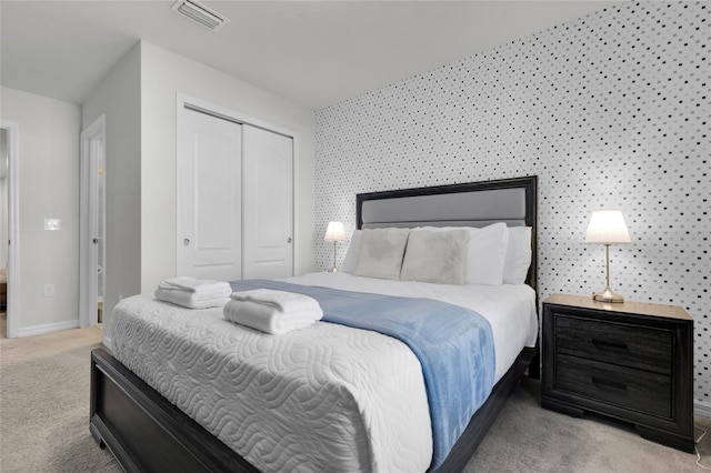 bedroom with baseboards, carpet, visible vents, and a closet