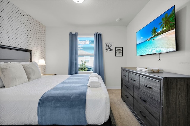 bedroom featuring light carpet and baseboards