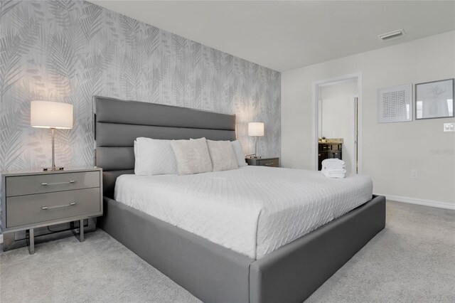 carpeted bedroom featuring baseboards, an accent wall, visible vents, and wallpapered walls