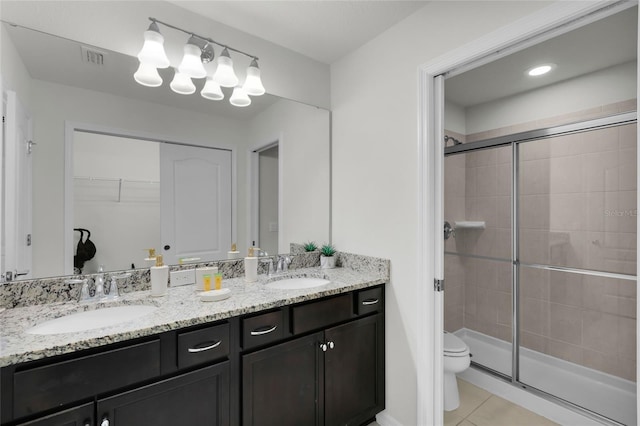 full bath with a stall shower, a sink, toilet, and tile patterned floors