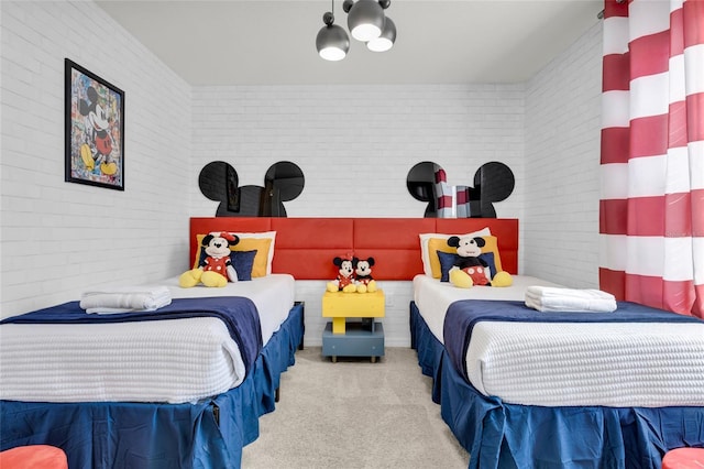 bedroom featuring carpet floors and brick wall