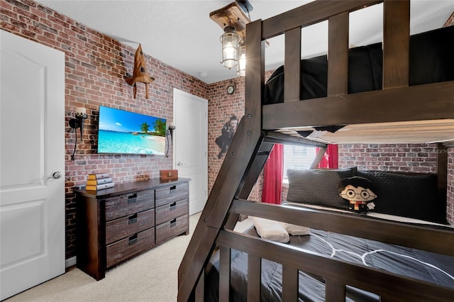 bedroom featuring brick wall, a textured ceiling, and carpet flooring