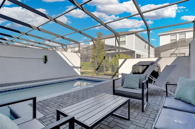 view of pool with a patio area, glass enclosure, and an outdoor hangout area