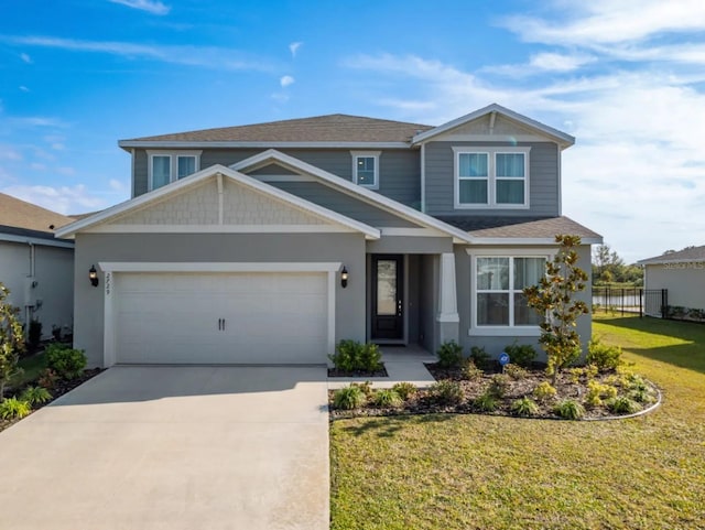 craftsman-style home with a garage, concrete driveway, fence, and a front lawn