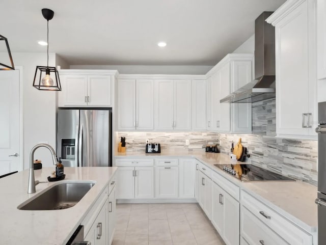 kitchen featuring black electric stovetop, a sink, white cabinetry, stainless steel fridge with ice dispenser, and wall chimney exhaust hood