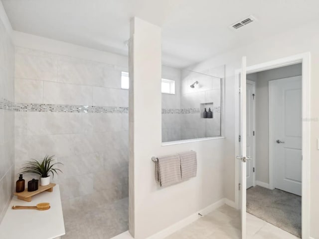 bathroom featuring a walk in shower, visible vents, and baseboards