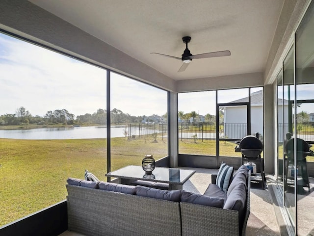 sunroom / solarium with a water view and a ceiling fan